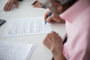Home Persoon bekijkt zorgverzekering slim op laptop met aantekeningen